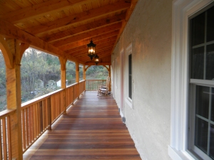 A great porch for rocking chairs with a view of the springhouse ruins. Mahogany floor boards and hemlock beams.